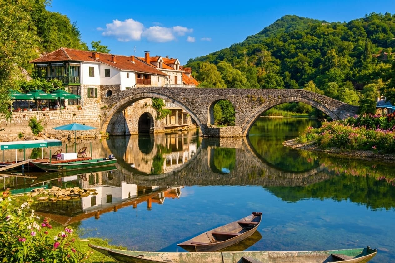 Rijeka Crnojevica panorama — Old Bridge, boats, and swan at golden hour